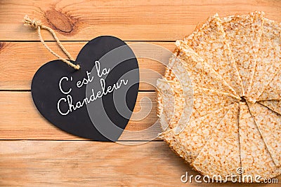 Top view of crepes french pancakes text c`est la chandeleur in a heart, rustic wood background Stock Photo