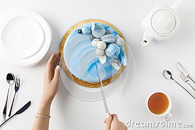 top view of cropped hands slicing cake on chopping board Stock Photo