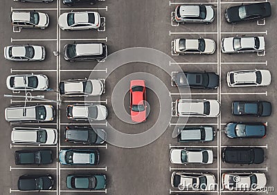 Top view of the crowded Parking lot with quadcopter or drone. Original bright automobile among the grey of mediocre cars. Parking Stock Photo