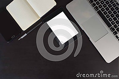 Top view of cup of coffee, keyboard, notebook, tablet, smartphone, green plant and notebook and pen at workplace. Editorial Stock Photo