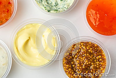 Top view on cups of various sauces and condiments on white background Stock Photo
