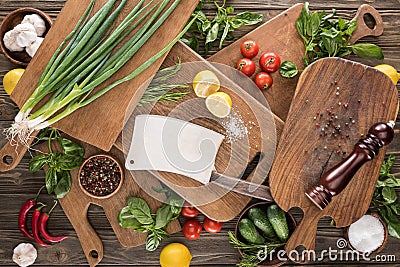 Top view of cutting boards, cherry tomatoes, salt, garlics, cucumbers, chili peppers, pepper mill, meat chopper, lemons Stock Photo