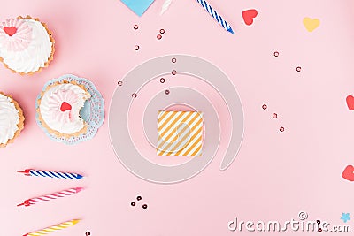 Top view of delicious cupcakes, colorful candles and hearts symbols on pink Stock Photo