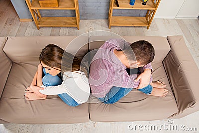 Top view of depresed man and woman sitting back to back on the sofa Stock Photo