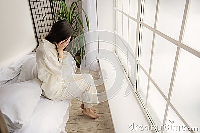 Top view of depressed asian woman sitting on bed Stock Photo