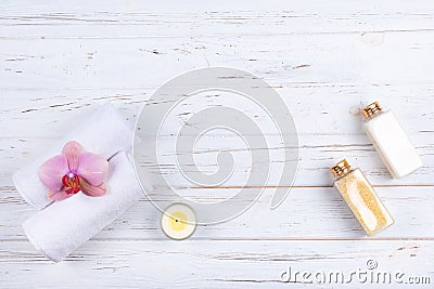Different spa, beauty and wellness products: cream, sea salt, towels, decorated with orchid flower and candle with copy space. Stock Photo