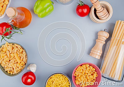 top view of different types of macaroni as tagliatelle ziti pipe-rigate bucatini with tomato salt garlic black pepper butter on Stock Photo