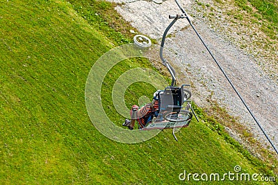 Top view disabled tourist ride on ski elevator with wheel chair behind his back. Summer day highlands tour Editorial Stock Photo