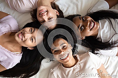 Top view diverse women best friends lying on bed together Stock Photo