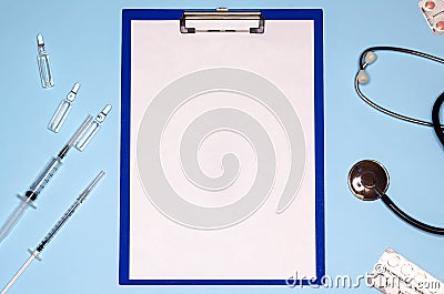 Doctors desktop, tablet for writing, syringes and ampoules with medicine, stethoscope, pills. Stock Photo