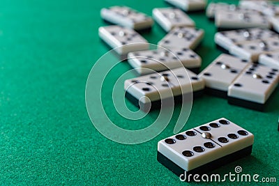 Top view of dominoes, the six double focused, the rest out of focus, on horizontal green mat Stock Photo