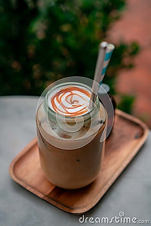 cafe with glas of flat-white coffee on near some flowers. Stock Photo