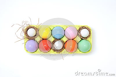 Top view of an Easter composition of painted eggs in bright juicy colors with a glossy texture that lie in a container with hay ne Stock Photo