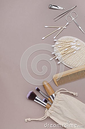 Top view of eco riendly beauty tools on the beige surface.Empty pace.Makeup brushes,comb,manicure set,sponge and ear brushes Stock Photo