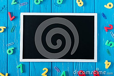 top view of empty blackboard colorful numbers and paper clips on blue wooden Stock Photo