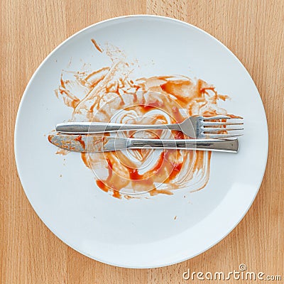 Top view of empty plate, tomato sauce smeared on finished plate. Stock Photo