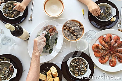 Top view of family eating seafood around a white table from high view angle Stock Photo