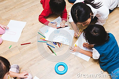 Top view Family happy children group kid boy and girl kindergarten paint drawing on peper with teacher education together Stock Photo