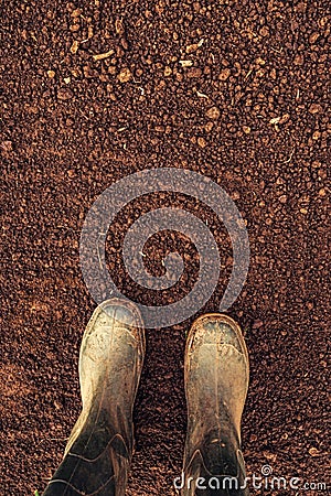 Top view of farmer rubber boots on ploughed arable land Stock Photo