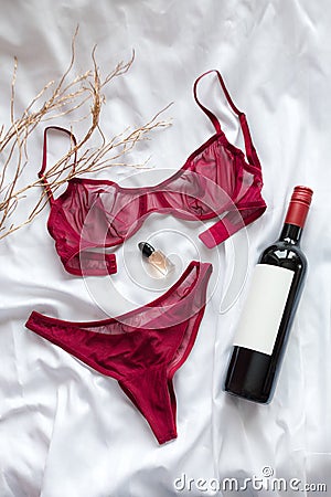 Top view fashion red lace lingerie with bootle of red wine and perfume. Set of woman essential accessory and underwear Stock Photo