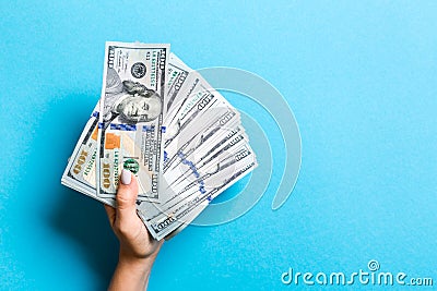 Top view of female hand holding a fan of money on colorful background. One hundred dollar bills. Credit and debt concept with copy Stock Photo