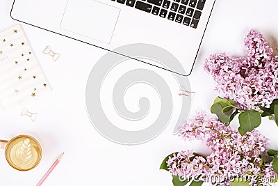 Top view of female worker desktop with laptop, flowers and different office supplies items. Feminine creative design workspace. Stock Photo