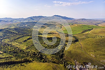 Top view of the field in Altai.Autumn view. Hilly terrain. Yellow slopes and trees contrast with green fields Stock Photo