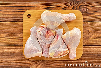 Five pieces fresh raw chicken legs on a bamboo chop board Stock Photo