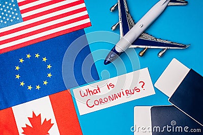 Top view of flags of countries near toy plane and card with what is coronavirus lettering Stock Photo