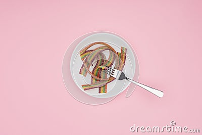 top view of flat colored jelly candies with sugar and fork on plate Stock Photo