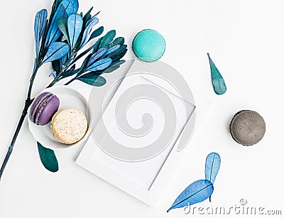 Top view flat lay Blank photo frame mockup with macarons and blue leaves Stock Photo
