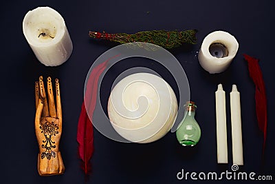 Flat lay esoteric still life with candles,feather, potion, juniper ,crystal ball and wooden hand Stock Photo