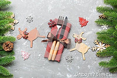 Top view of flatware tied up with ribbon on napkin on cement background. Close up of christmas decorations and reindeer. New Year Stock Photo