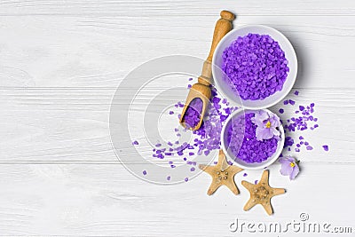 Flavored purple sea salt crystals with violet flower and starfishes on white Stock Photo