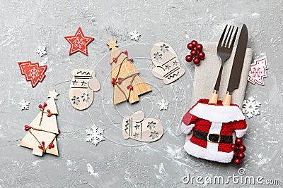 Top view of fork and knife tied up with ribbon on napkin on cement background. Close up of christmas decorations and New Year tree Stock Photo