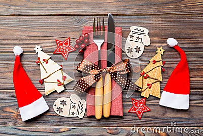 Top view of fork and knife tied up with ribbon on napkin on wooden background. Close up of christmas decorations and New Year tree Stock Photo