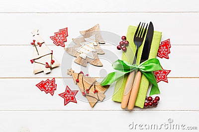 Top view of fork and knife tied up with ribbon on napkin on wooden background. Close up of christmas decorations and New Year tree Stock Photo