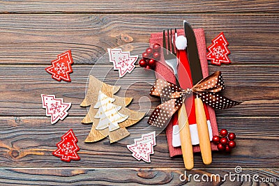Top view of fork and knife tied up with ribbon on napkin on wooden background. Close up of christmas decorations and New Year tree Stock Photo