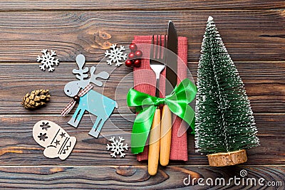 Top view of fork and knife tied up with ribbon on napkin on wooden background. Close up of christmas decorations and New Year tree Stock Photo