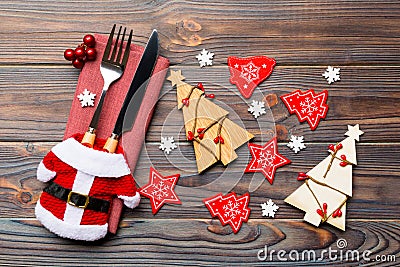 Top view of fork and knife tied up with ribbon on napkin on wooden background. Close up of christmas decorations and New Year tree Stock Photo