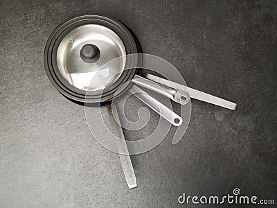 Top view of four stainless steel pans on the dark gray concrete floor Stock Photo