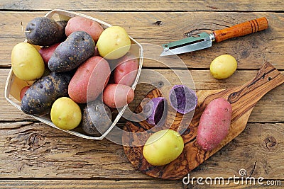 Fresh colorfull potatoes on rustic table background Stock Photo