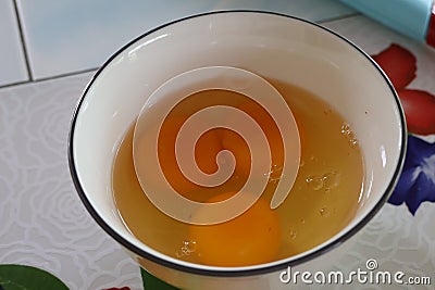 Top view, fresh cracked eggs in white ceramic cup, breakfast cooking concept Stock Photo