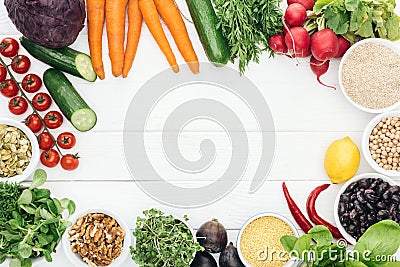 Top view of fresh fruits and vegetables near glass jars on wooden white table with copy space. Stock Photo