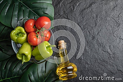 Top view of fresh vegetables, tomato and pepper in glass bowl and bottle of oil Stock Photo