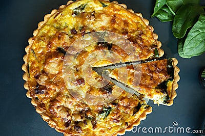 Top view freshly bake leek bacon spinach quiche on dark background Stock Photo