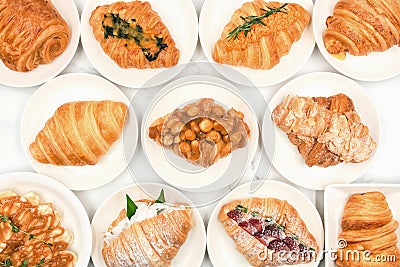 Top view of freshly baked delicious croissants, various types and flavors on white plate, Homemade isolate with white background. Stock Photo