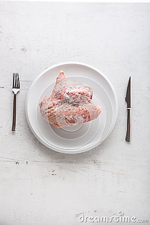 Top of view frozen turkey chicken on white plate with fork and k Stock Photo