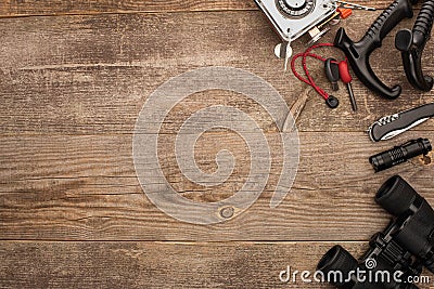 Top view of gas burner, spark lighter, trekking poles, jackknife, flashlight and binoculars Stock Photo