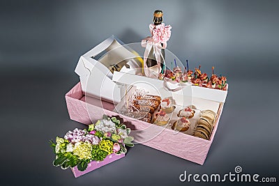 Top view of gift boxes and delicious candies, snacks, sweets, wine and chocolate pieces on black Stock Photo